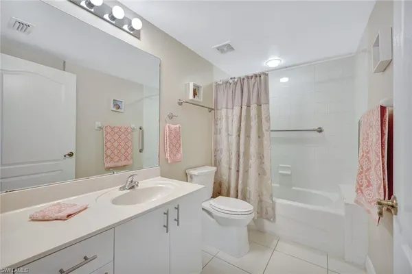 a bathroom with a shower sink vanity mirror and toilet