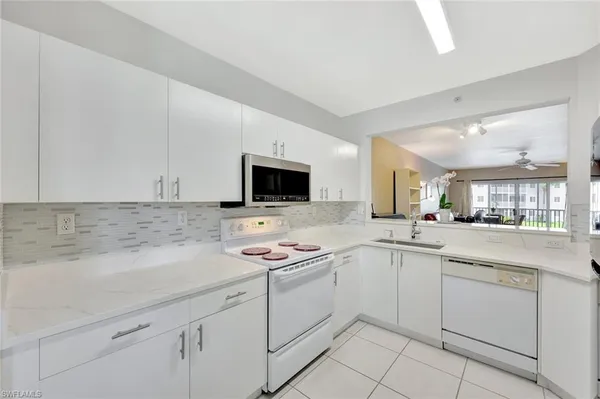 a kitchen with white cabinets sink and white appliances