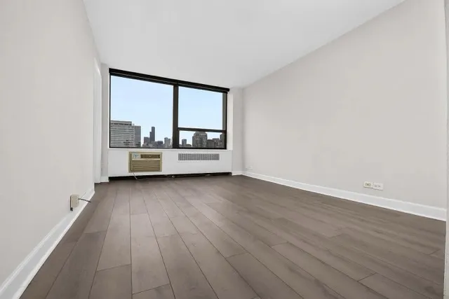a view of a room with wooden floor and furniture