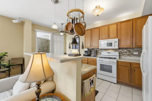 a kitchen with kitchen island granite countertop cabinets a sink a window and stainless steel appliances