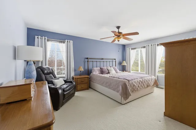 a bedroom with a bed couch chandelier and a window