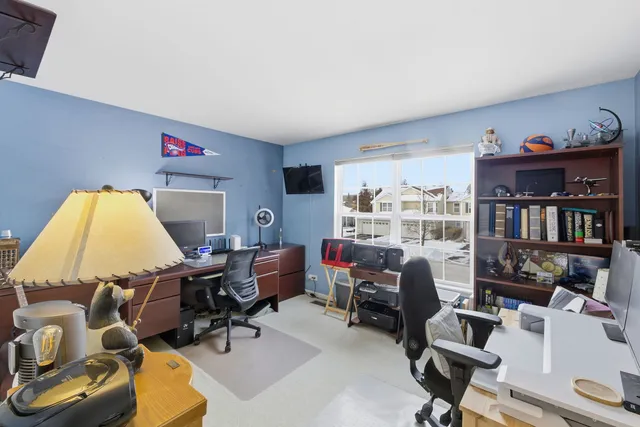 a view of a workspace with furniture and a window
