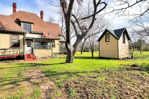 a view of a yard with a house and a tree