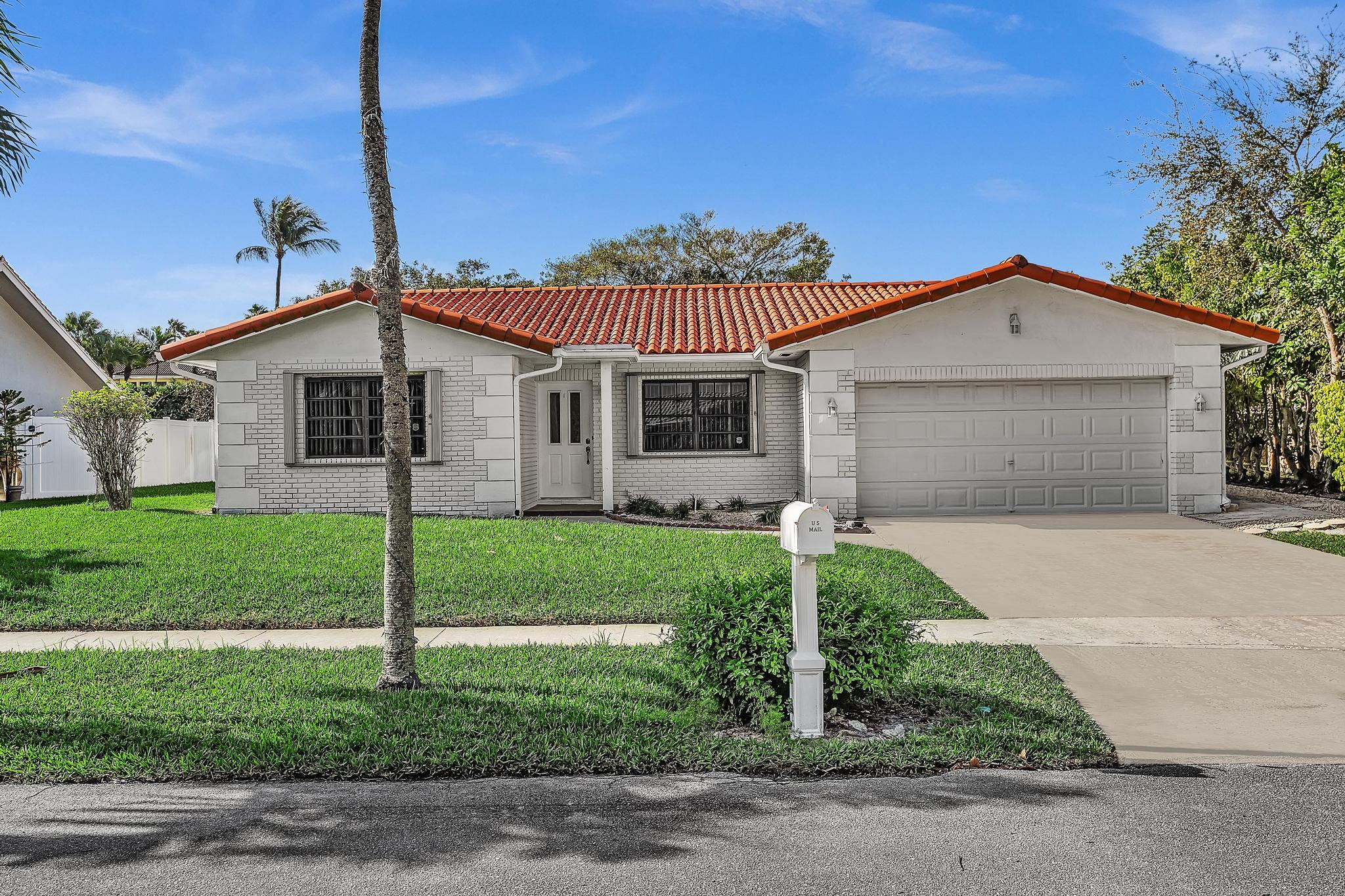 a front view of a house with a garden and plants