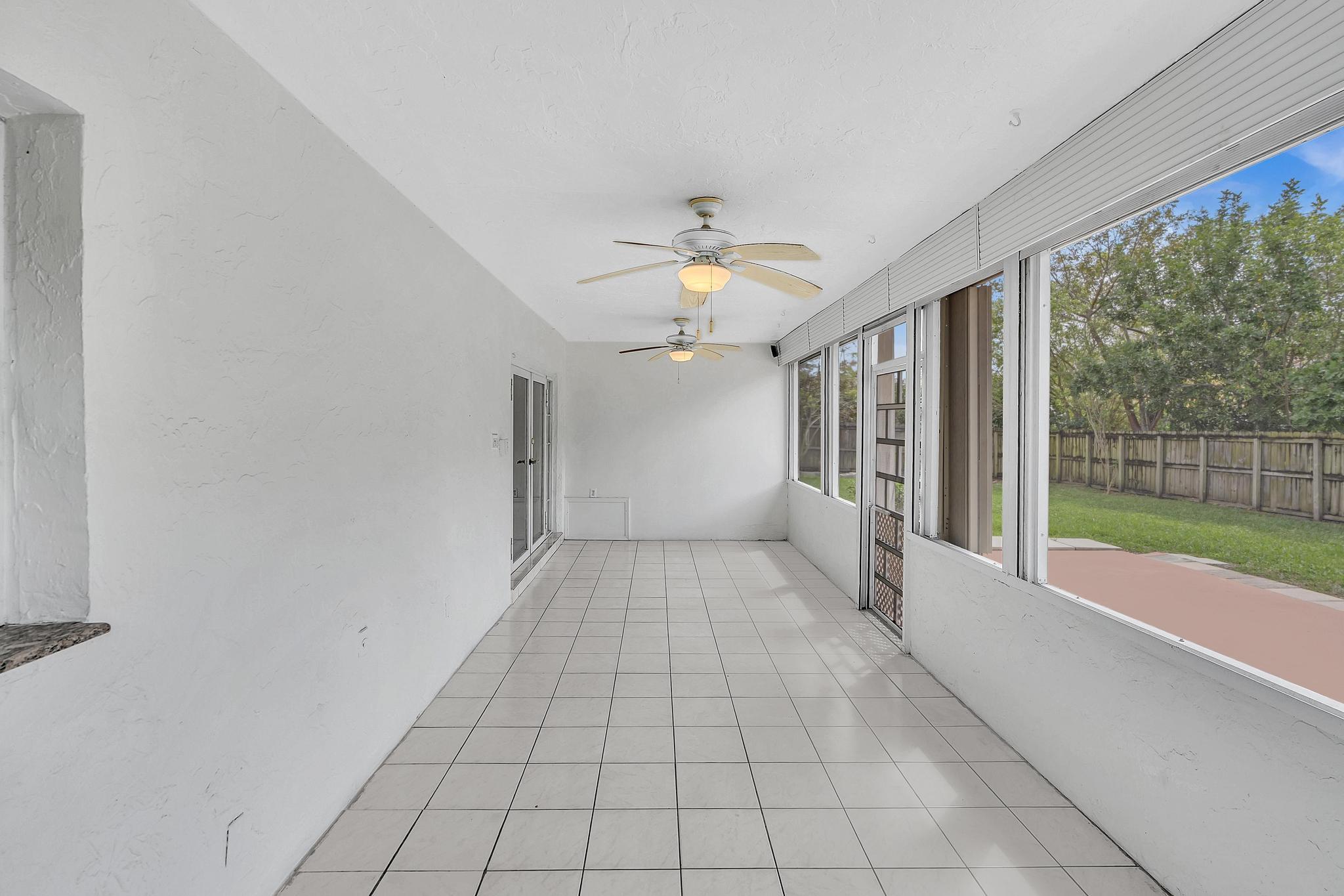 6144 Royal Lytham Drive Boca Raton, FL 33433 - Photo 33 of 70 a view of a porch with wooden floor and a floor to ceiling window