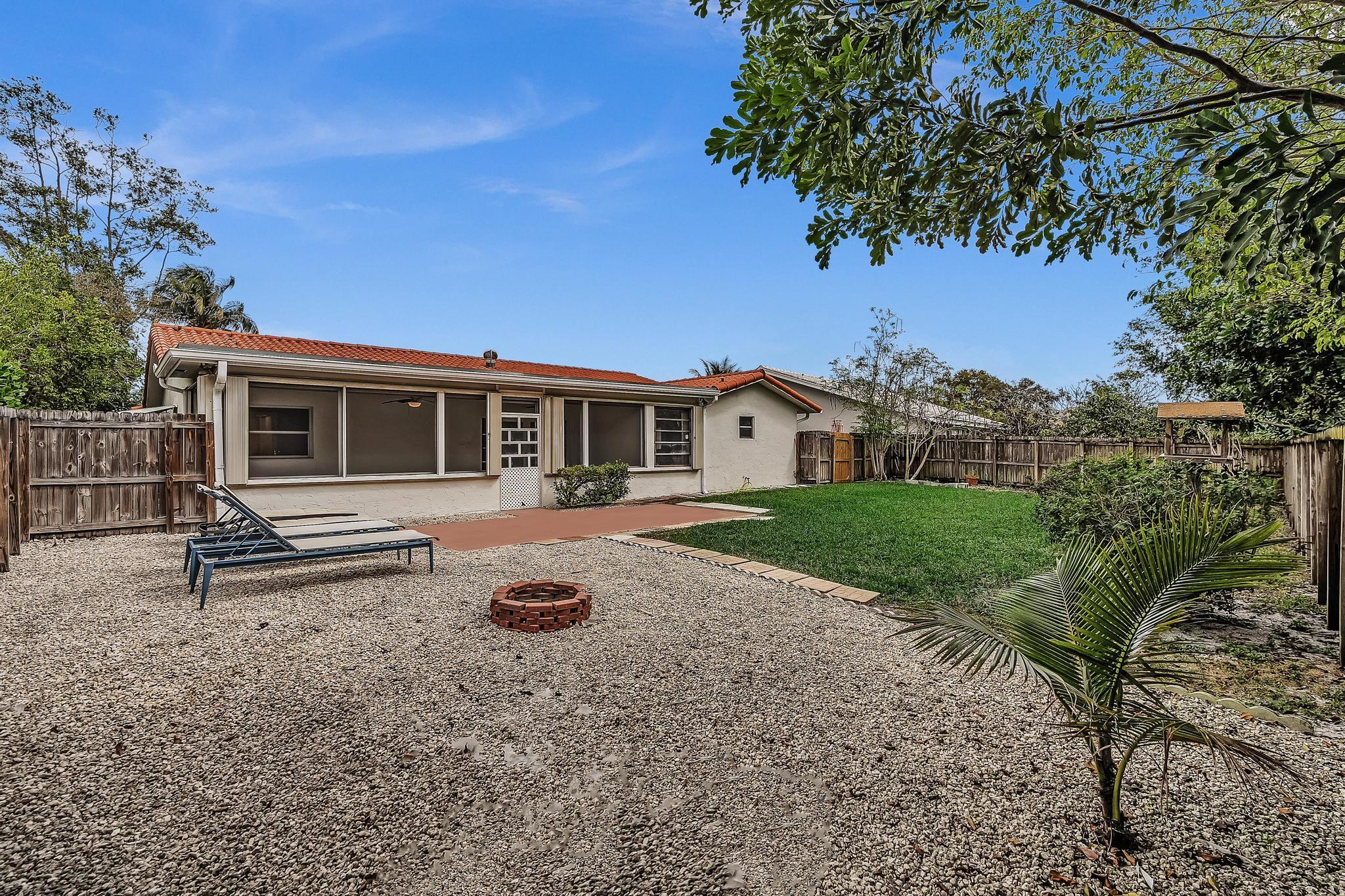 6144 Royal Lytham Drive Boca Raton, FL 33433 - Photo 38 of 70 a front view of a house with yard tree and wooden fence