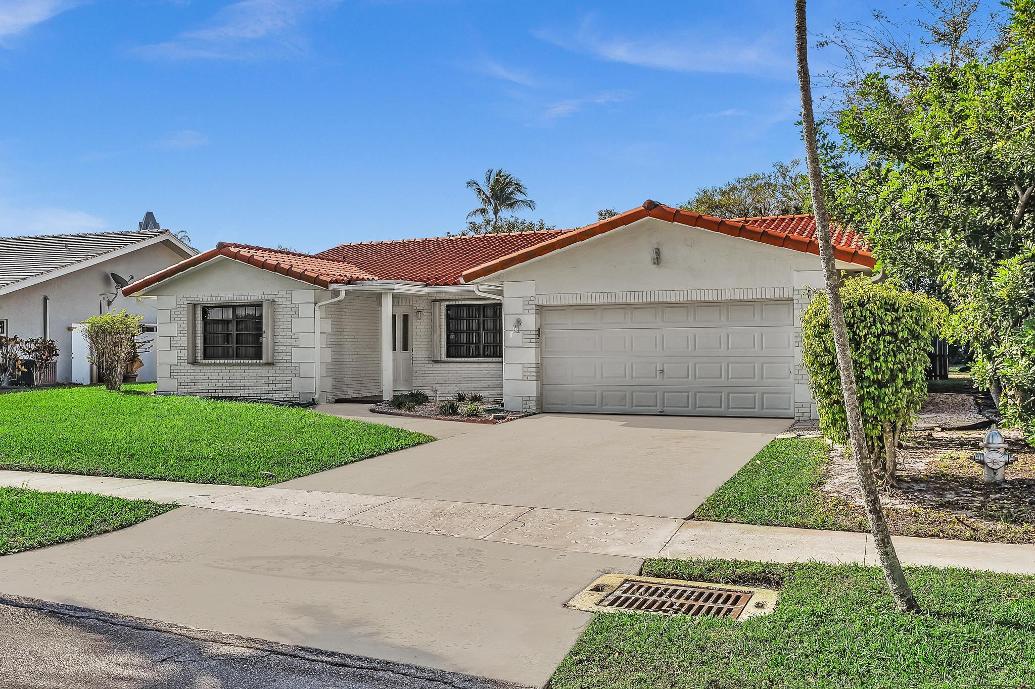 6144 Royal Lytham Drive Boca Raton, FL 33433 - Photo 4 of 70 a front view of a house with a yard and garage