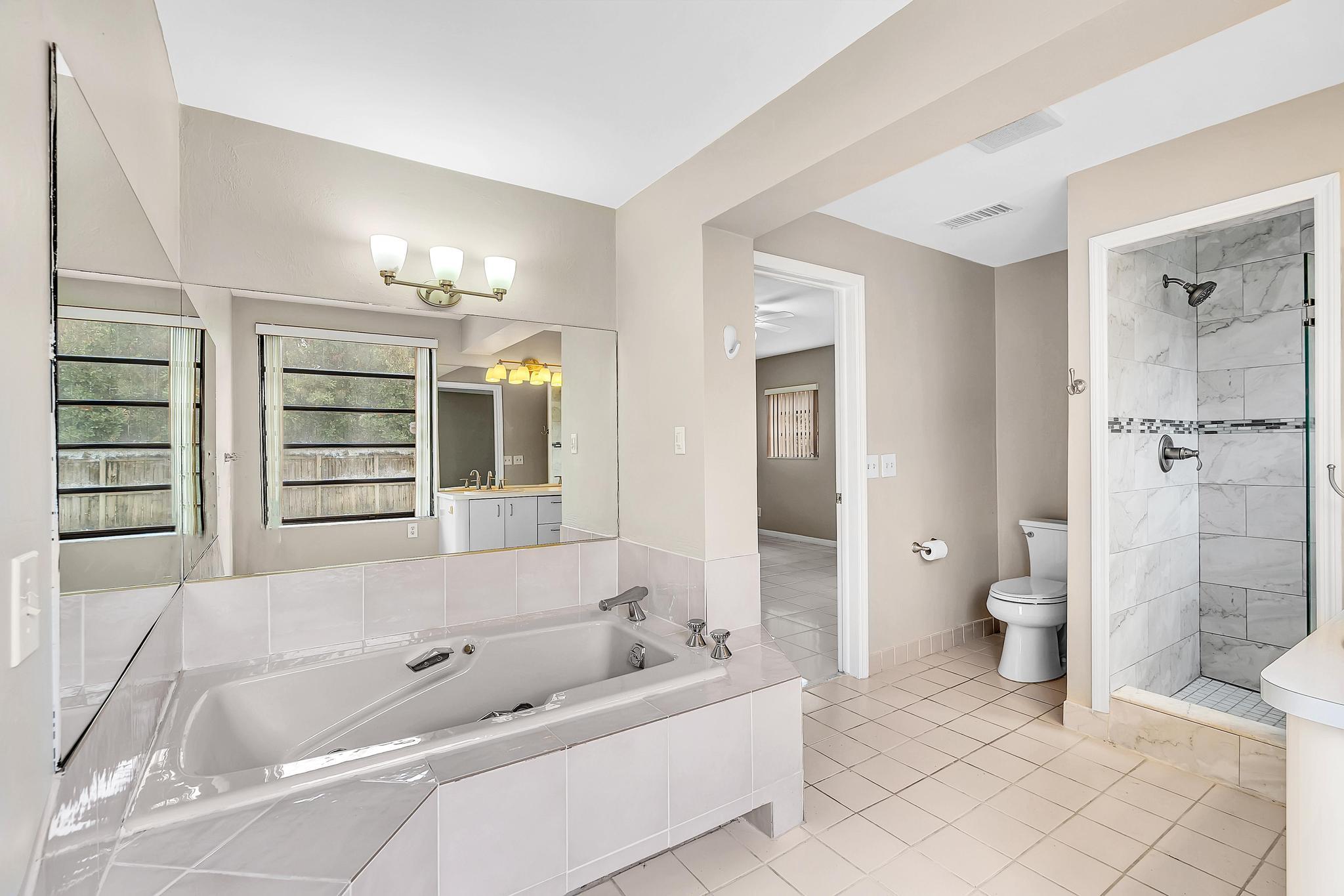 6144 Royal Lytham Drive Boca Raton, FL 33433 - Photo 49 of 70 a bathroom with a tub a toilet and a shower