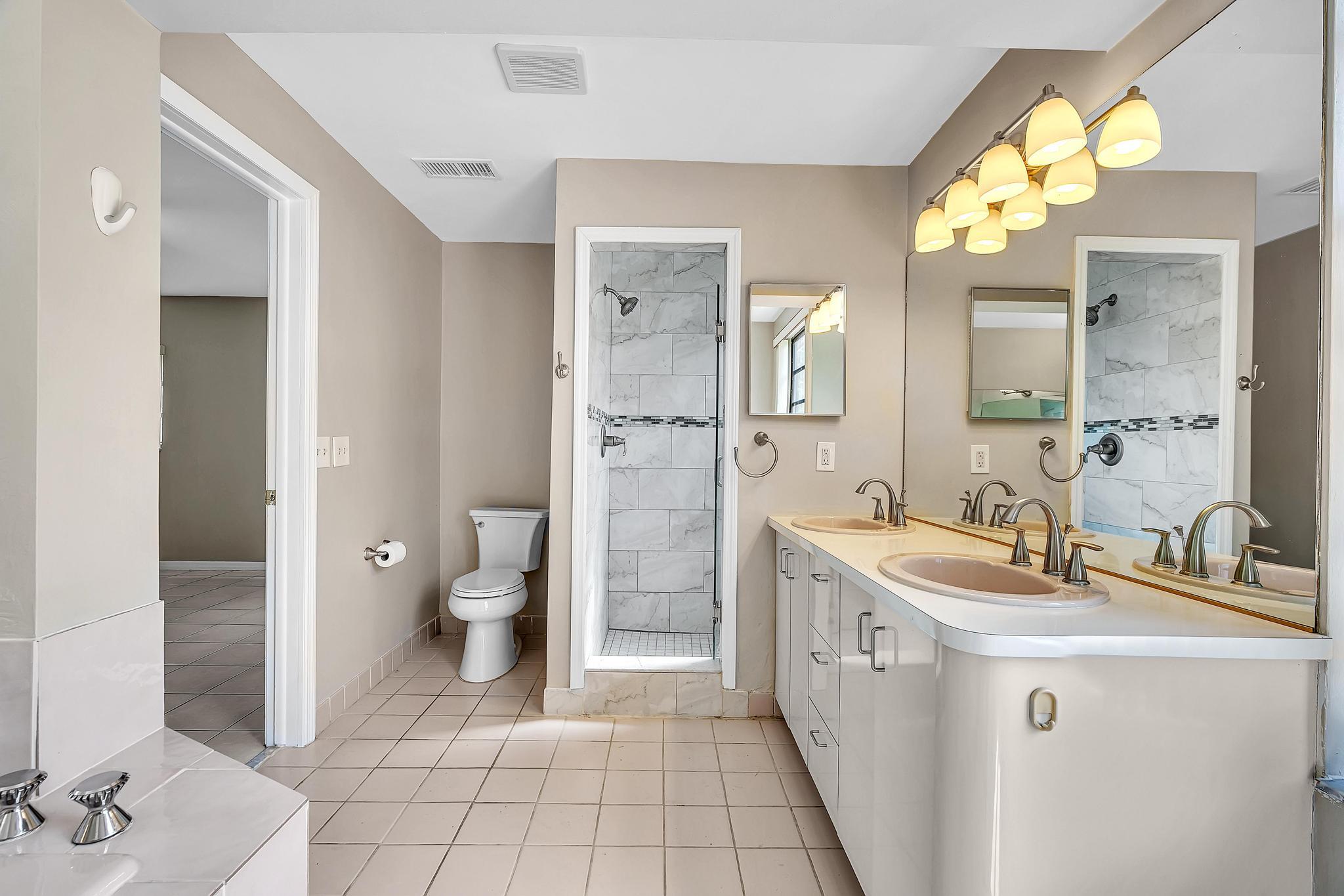 6144 Royal Lytham Drive Boca Raton, FL 33433 - Photo 50 of 70 a bathroom with a double vanity sink mirror and toilet