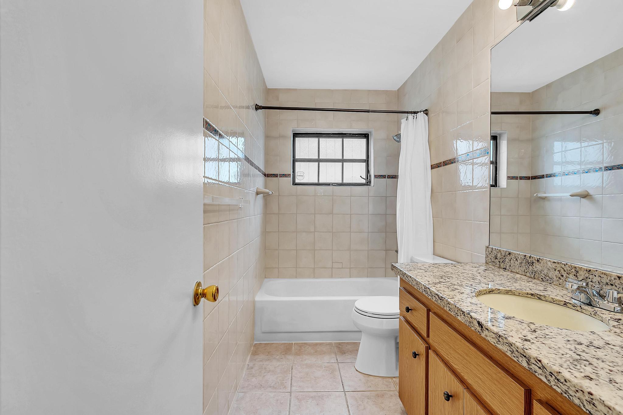 6144 Royal Lytham Drive Boca Raton, FL 33433 - Photo 57 of 70 a bathroom with a granite countertop sink a toilet and bathtub