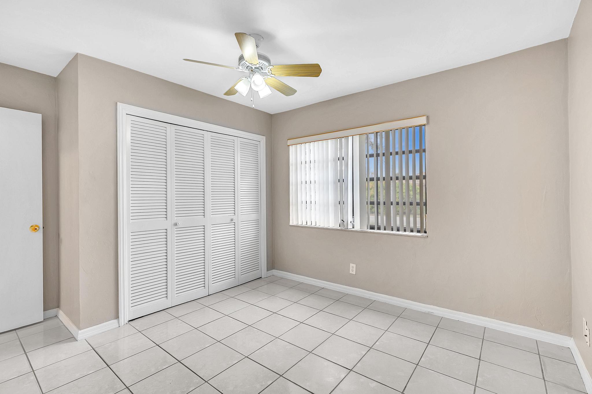 6144 Royal Lytham Drive Boca Raton, FL 33433 - Photo 61 of 70 a view of an empty room with window and chandelier fan