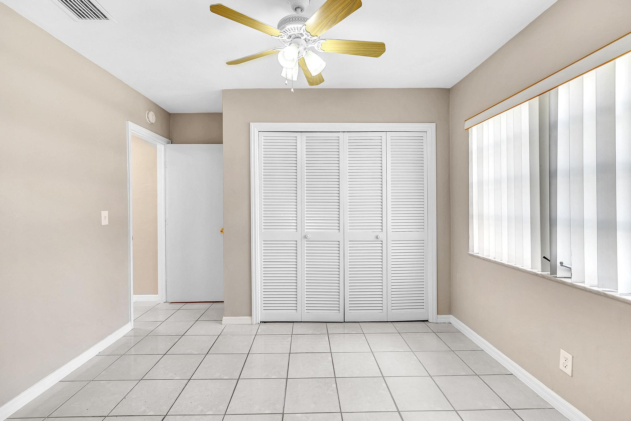6144 Royal Lytham Drive Boca Raton, FL 33433 - Photo 62 of 70 a view of an empty room with window and chandelier fan