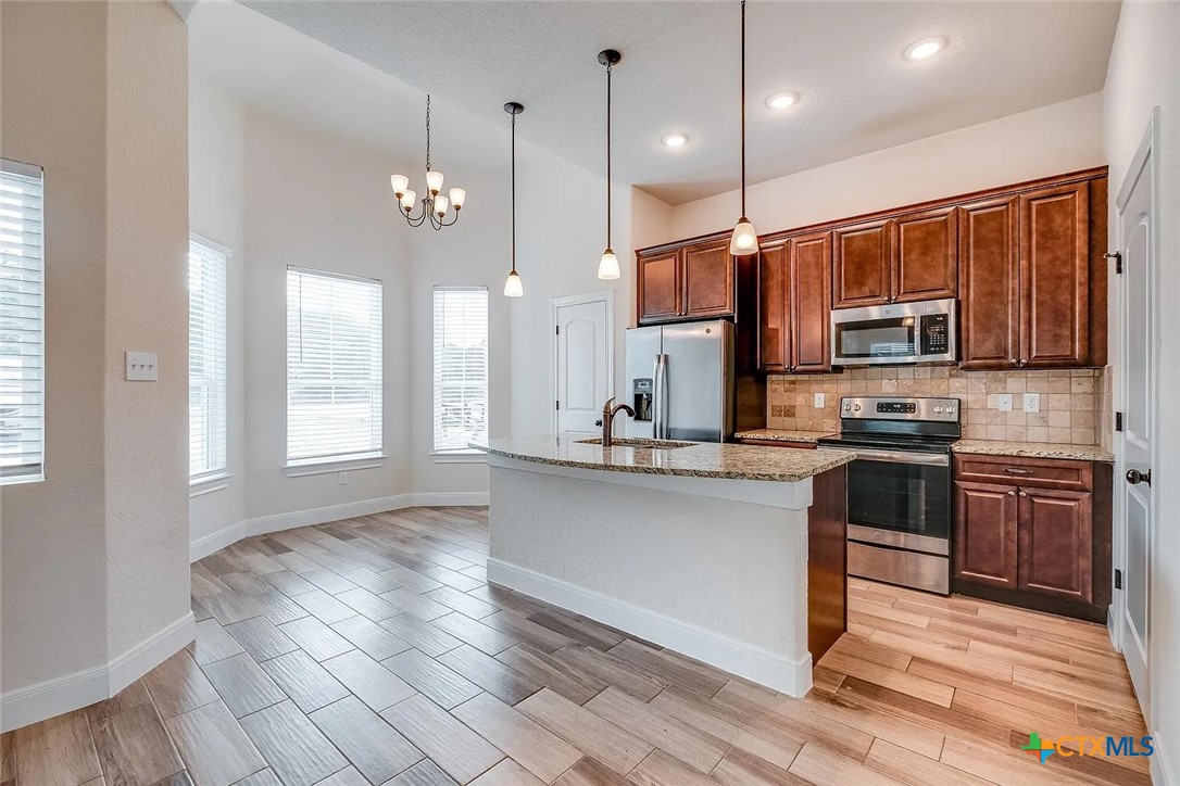 3133 Puter Creek Road, Unit B Spring Branch, TX 78070 - Photo 6 of 19 a kitchen with stainless steel appliances granite countertop a stove a sink and a microwave