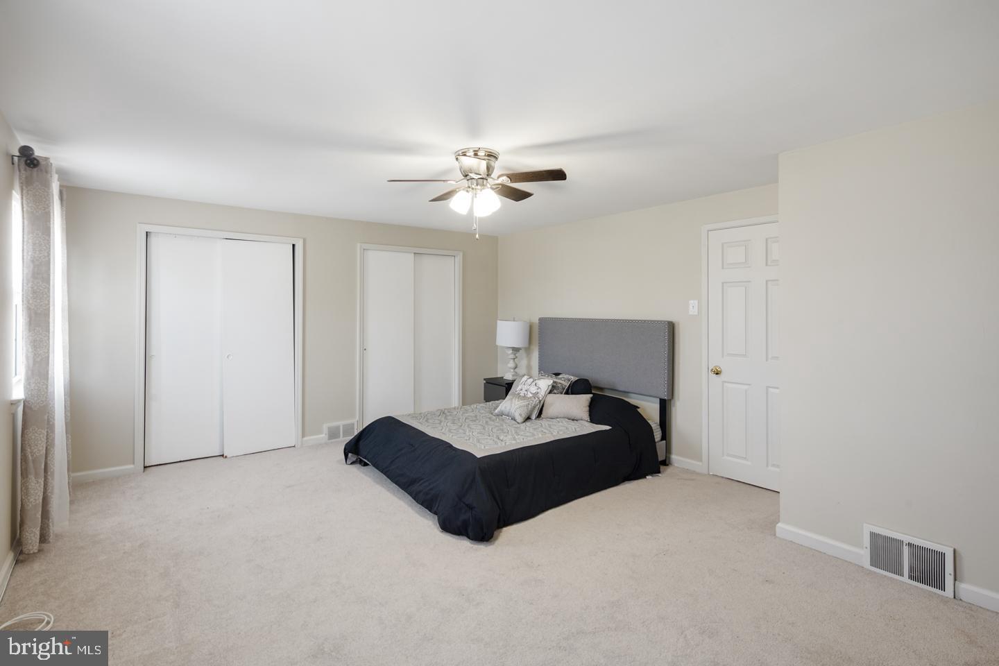 12519 Medford Road Philadelphia, PA 19154 - Photo 18 of 20 a spacious bedroom with a bed and a ceiling fan