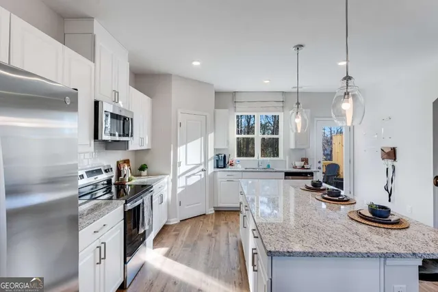 a kitchen with granite countertop a sink stove and refrigerator
