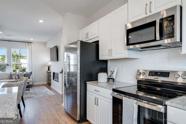 a kitchen with stainless steel appliances a stove microwave and refrigerator