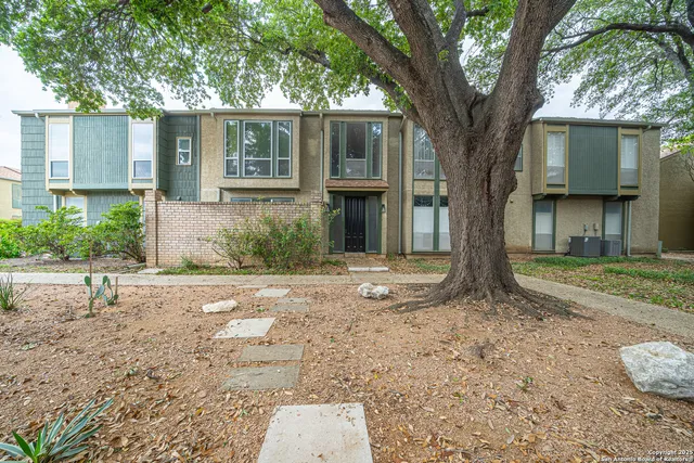 a tree in front of a white house