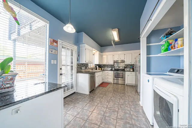 a kitchen with white cabinets and white appliances