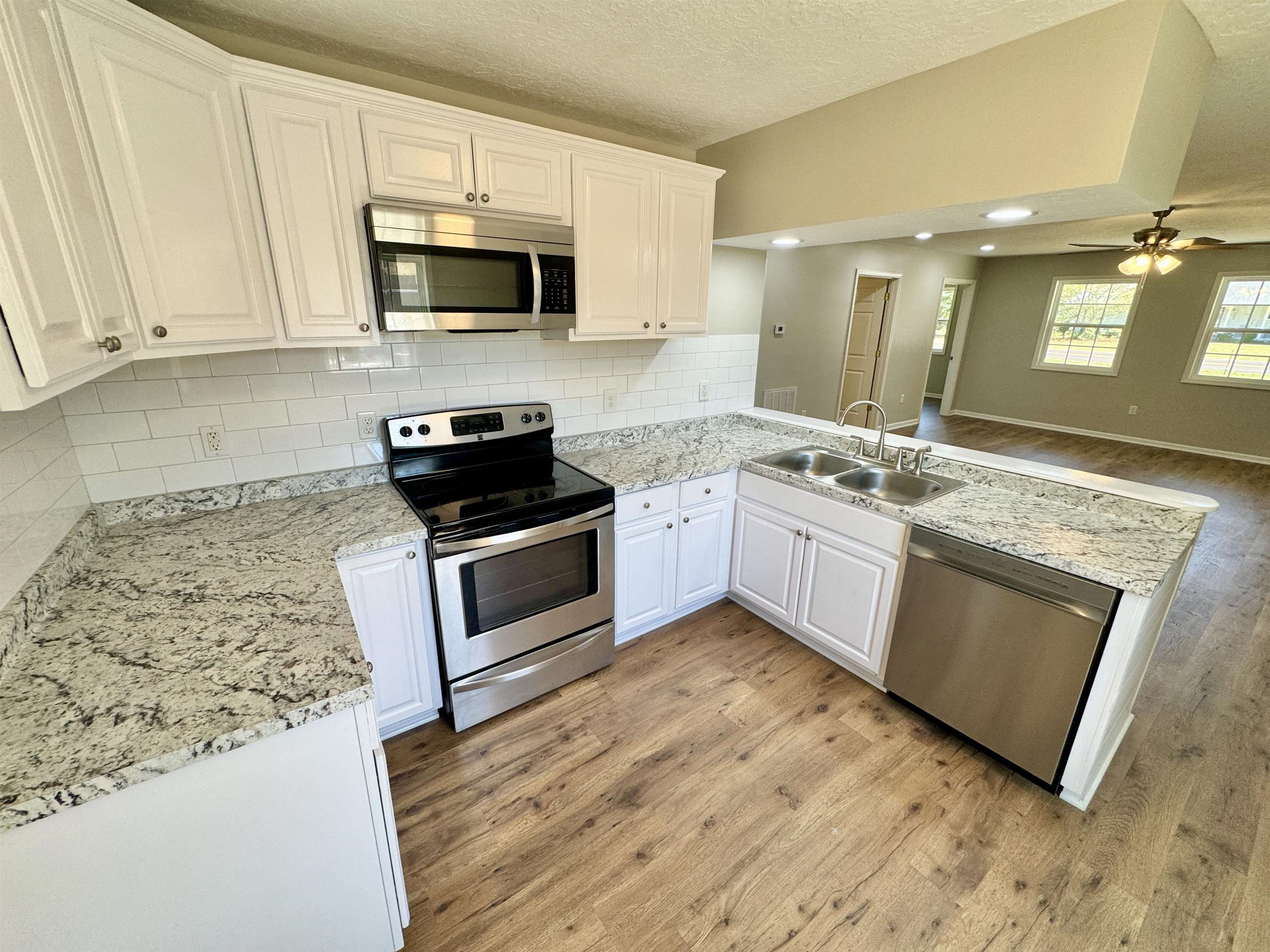 4638 Asbury Glimp Road Ripley, TN 38063 - Photo 6 of 16 a kitchen with stainless steel appliances granite countertop a stove a sink and a microwave
