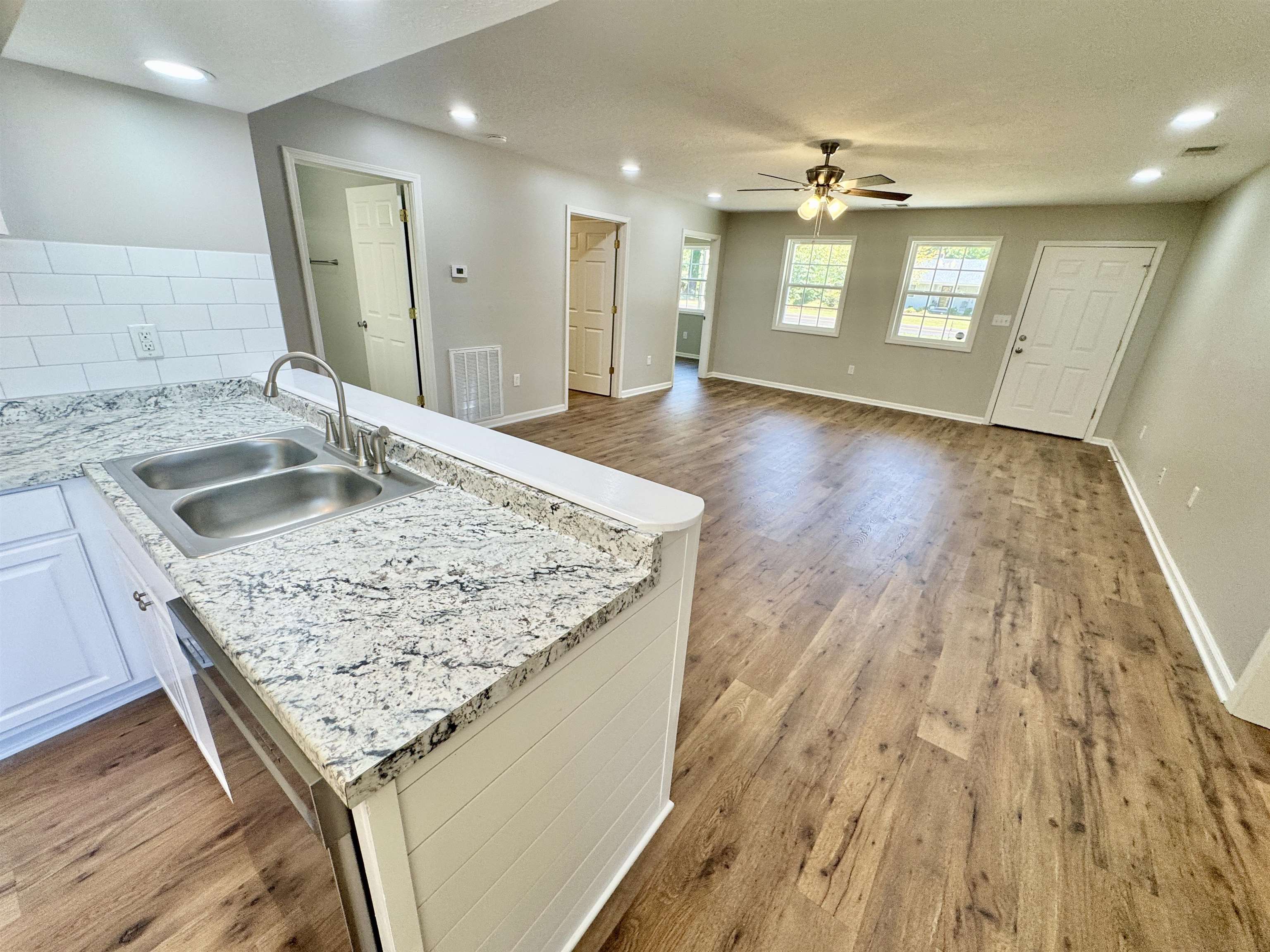 4638 Asbury Glimp Road Ripley, TN 38063 - Photo 16 of 16 a view of a kitchen with kitchen island a sink wooden floor and a glass door shower