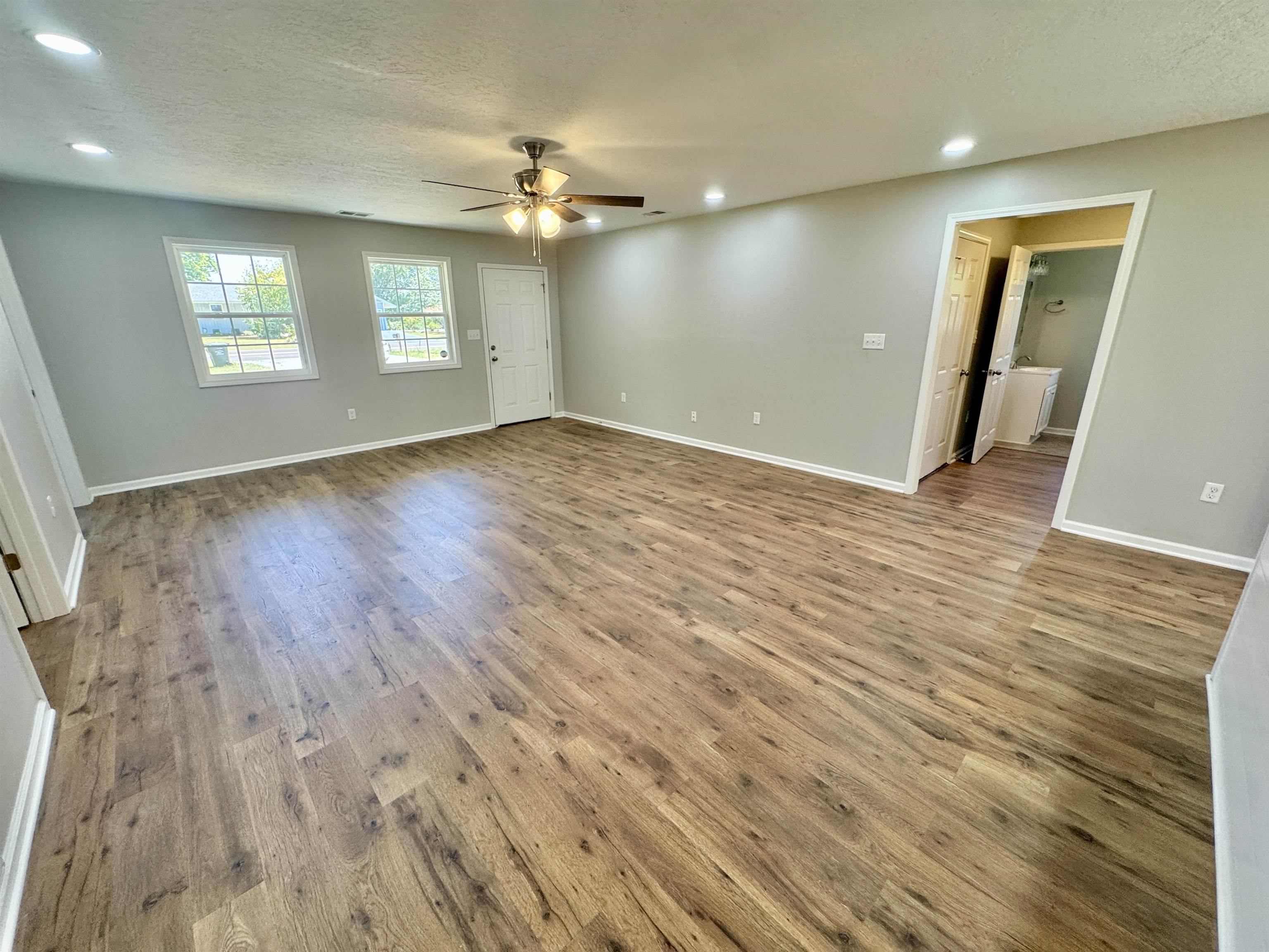 4638 Asbury Glimp Road Ripley, TN 38063 - Photo 9 of 16 an empty room with wooden floor and windows