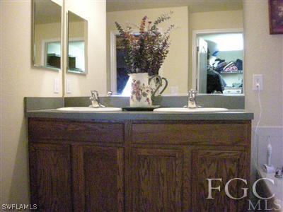 9017 Morris Road Fort Myers, FL 33967 - Photo 8 of 10 a bathroom with a granite countertop sink and a mirror