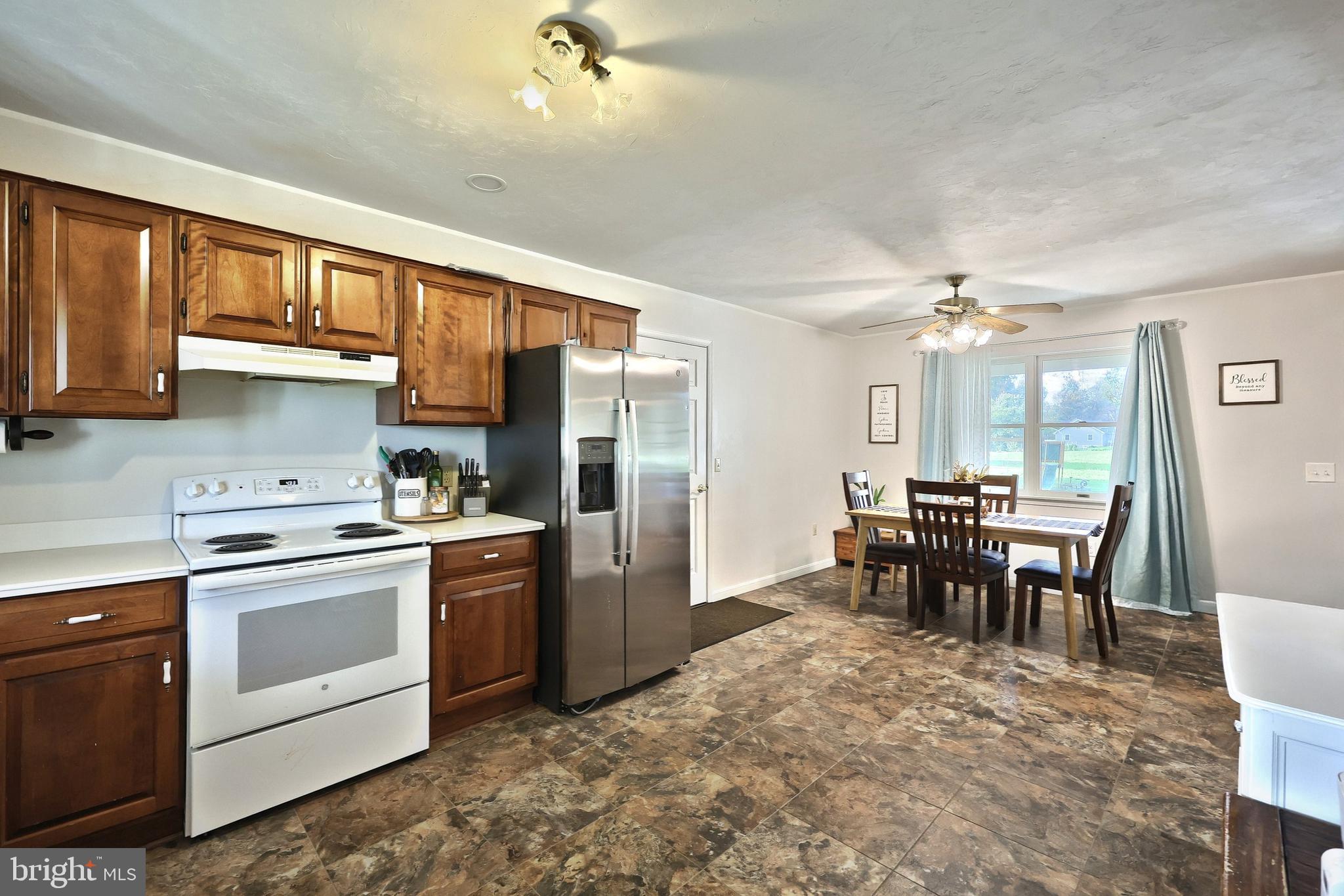 4877 Battlehill Road Brogue, PA 17309 - Photo 18 of 49 a kitchen with stainless steel appliances granite countertop a stove top oven a sink dishwasher a dining table and chairs with wooden floor