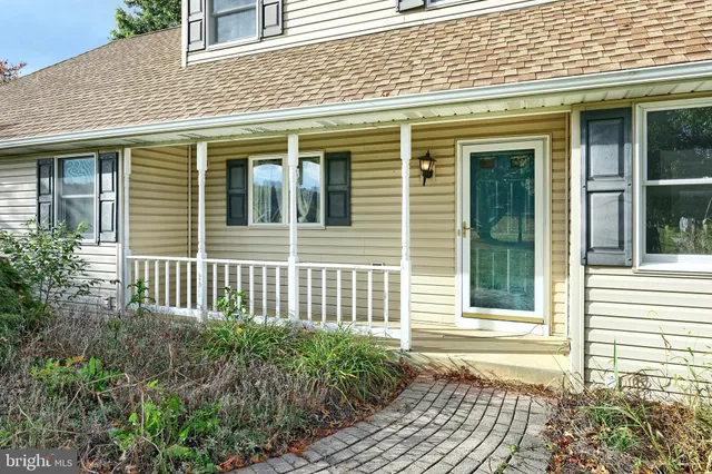 a view of a house with a small deck and a garden