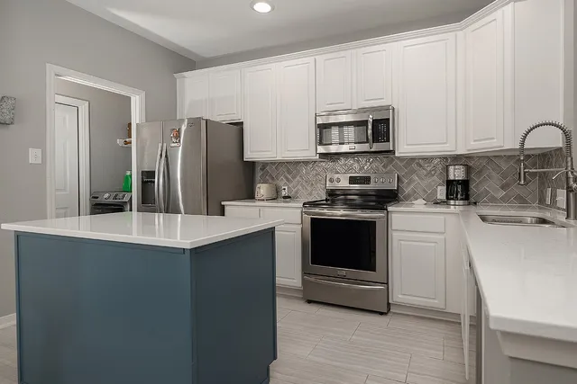 a kitchen with stainless steel appliances a stove microwave and sink