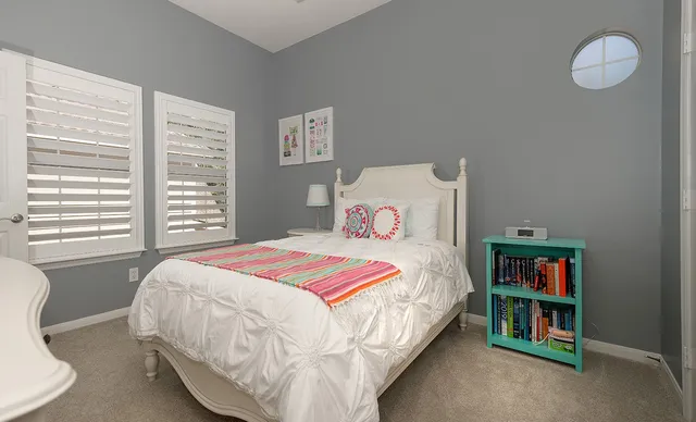 a bedroom with a bed and a large window