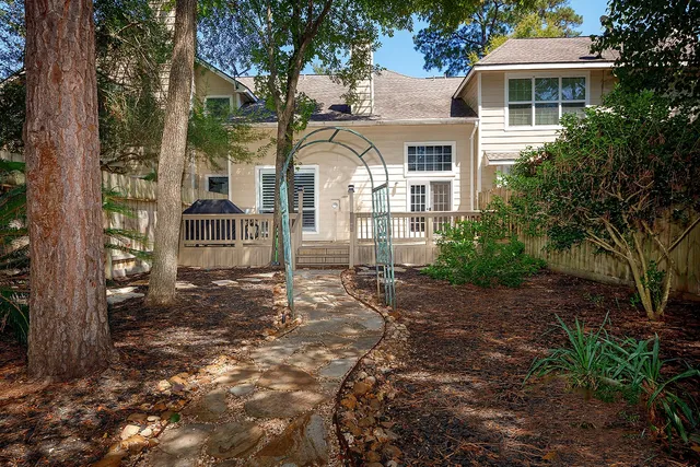 a view of a white house with a yard and large tree