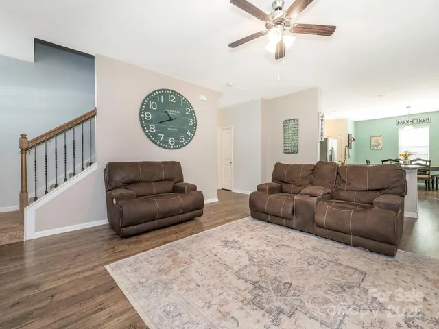 a living room with couches a fireplace and a window