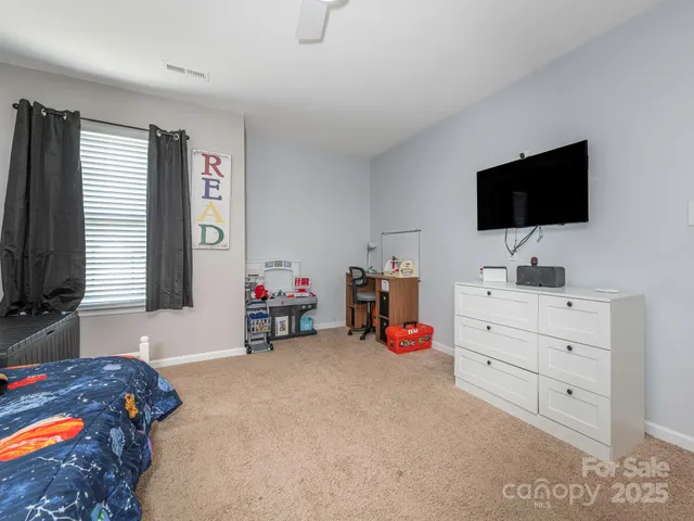 a bedroom with a bed and flat screen tv