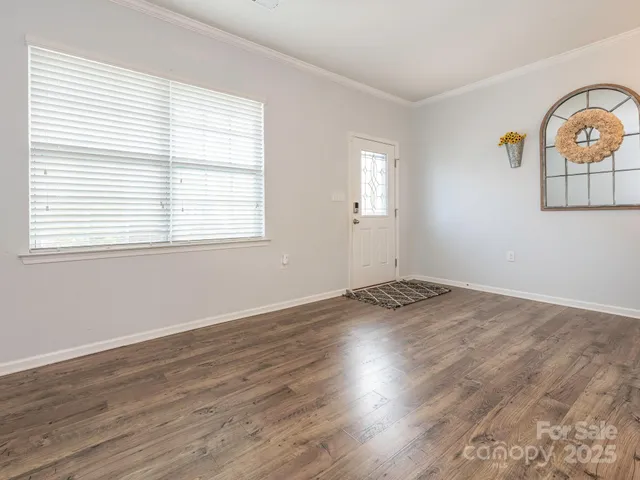 an empty room with wooden floor and window