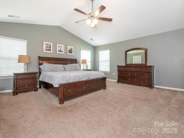 a spacious bedroom with a bed and a chandelier