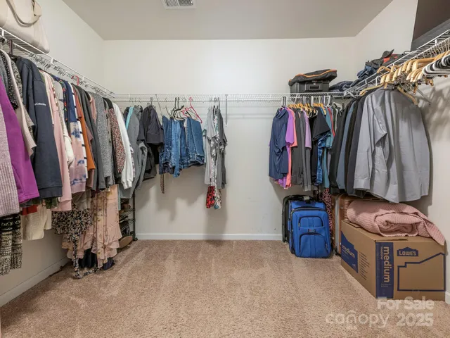 a view of walk in closet with clothes
