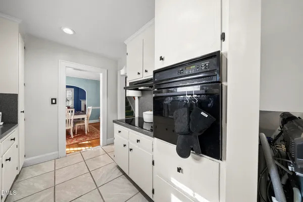 a kitchen with white cabinets and appliances