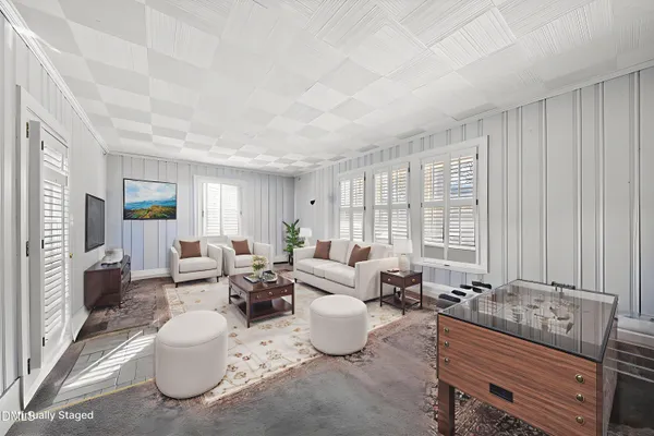 a living room with furniture and large windows