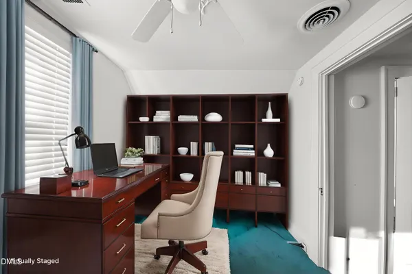 a view of a workspace with a window and lounge chair