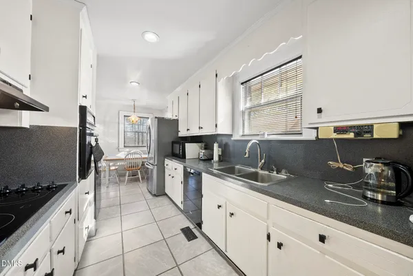 a kitchen with stainless steel appliances a sink stove and cabinets