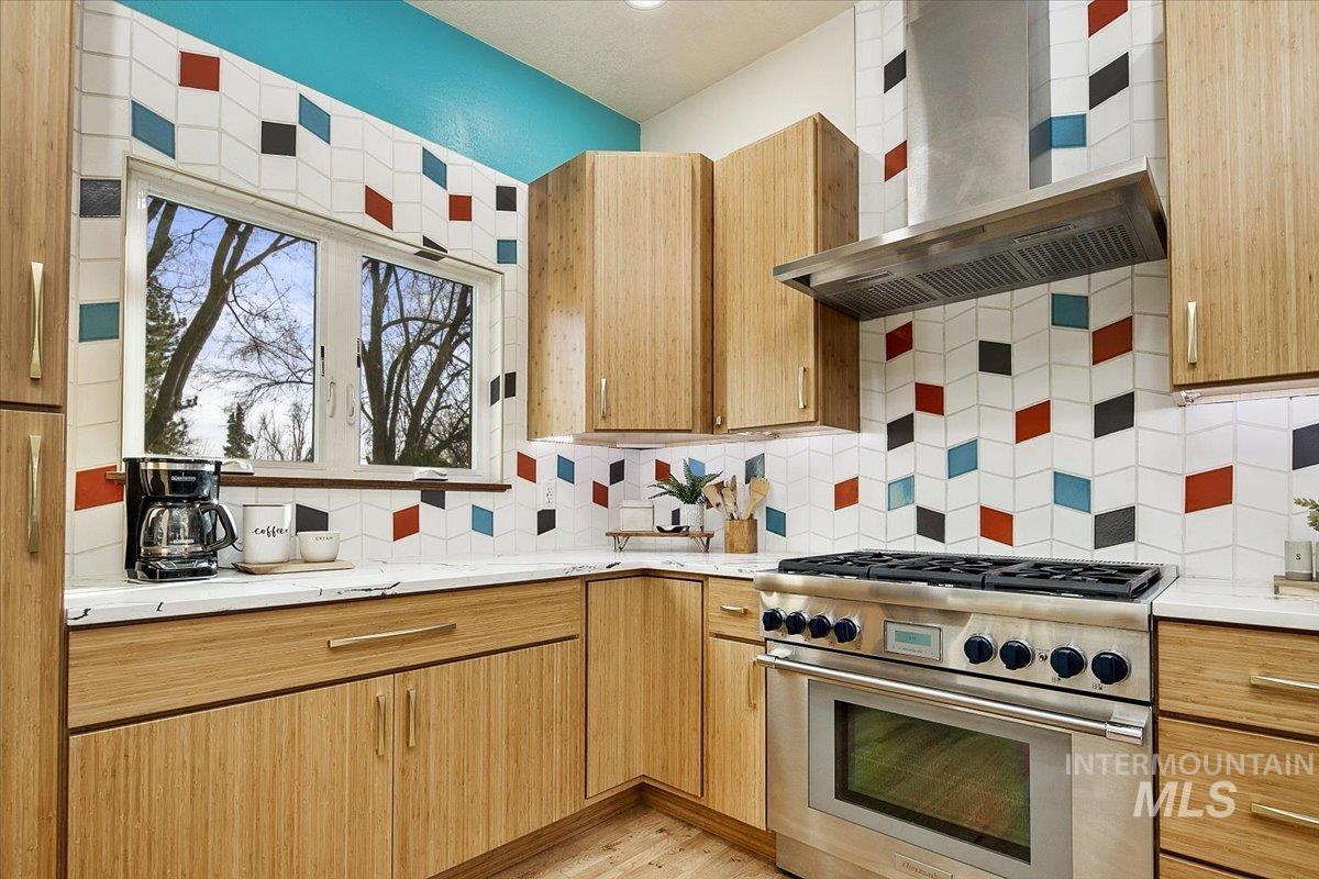 2518 Lancaster Drive Boise, ID 83702 - Photo 11 of 41 Kitchen featuring high end stainless steel range, tasteful backsplash, light stone counters, and light wood finished floors