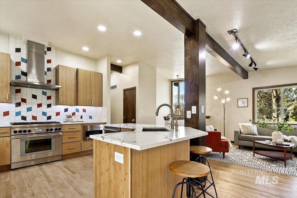 2518 Lancaster Drive Boise, ID 83702 - Photo 12 of 41 Kitchen featuring a textured ceiling, stainless steel appliances, track lighting, light stone countertops, and decorative backsplash