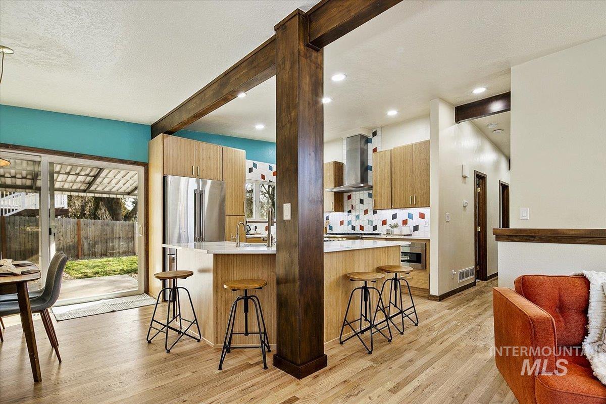2518 Lancaster Drive Boise, ID 83702 - Photo 13 of 41 Kitchen featuring beam ceiling, a breakfast bar area, light wood finished floors, an island with sink, and a textured ceiling