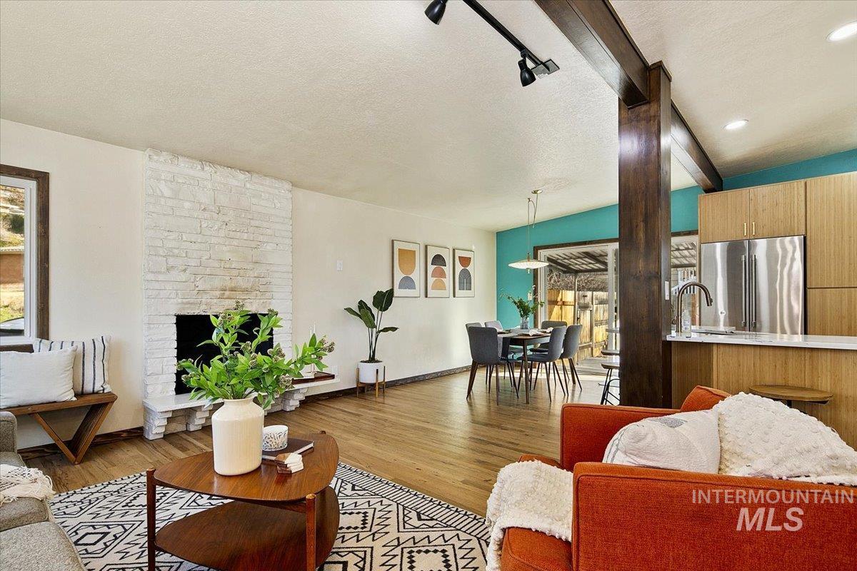 2518 Lancaster Drive Boise, ID 83702 - Photo 15 of 41 Living room featuring wood finished floors, a stone fireplace, and rail lighting