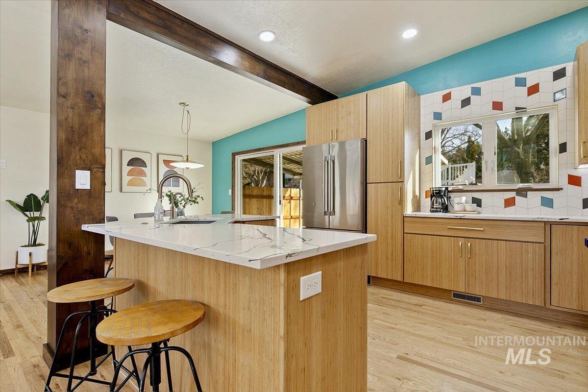 2518 Lancaster Drive Boise, ID 83702 - Photo 7 of 41 Kitchen featuring a breakfast bar, light stone counters, high end refrigerator, light wood-style floors, and beam ceiling