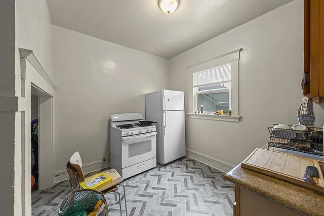 a kitchen with a stove a refrigerator and a stove top oven