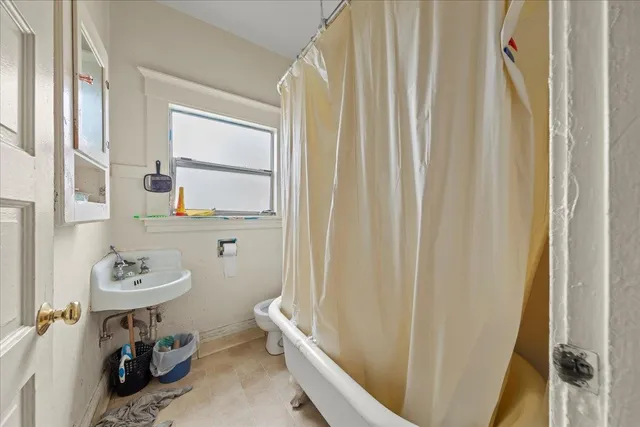 a bathroom with a sink toilet and window