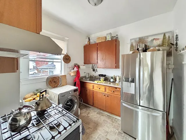 a kitchen with a refrigerator and a stove top oven