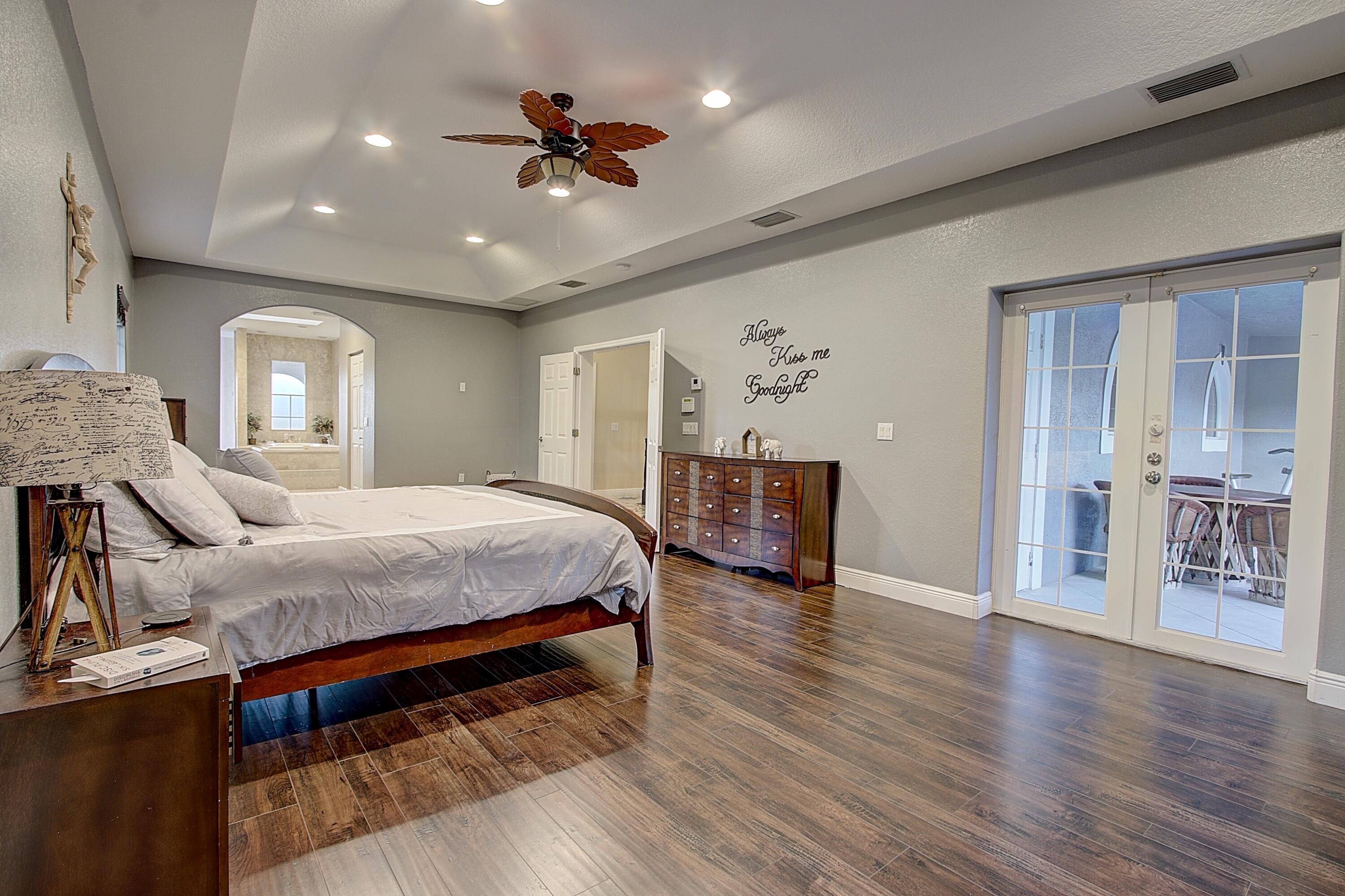 669 Howard Street Fort Pierce, FL 34982 - Photo 14 of 15 a spacious bedroom with a bed and a chandelier