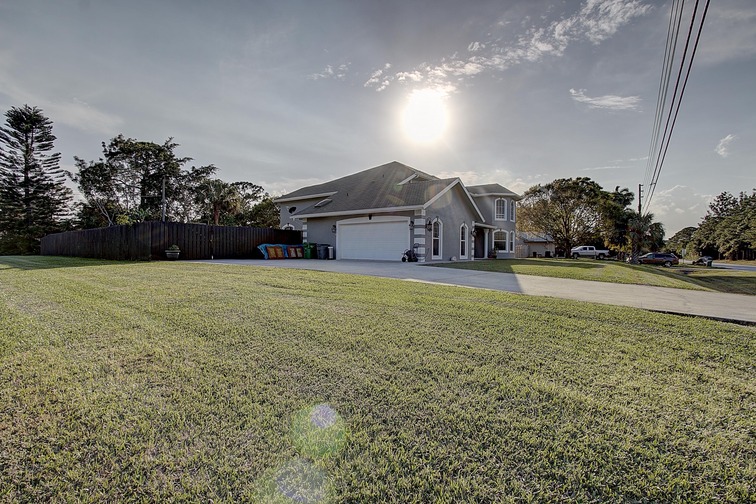 669 Howard Street Fort Pierce, FL 34982 - Photo 4 of 15 a front view of a house with a big yard and large trees
